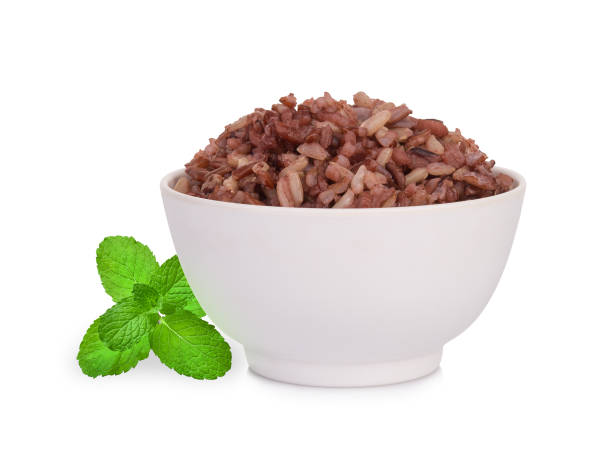 коричневый рис в белой миске с листом мяты изолированы на белом фоне - brown rice rice cooked healthy eating стоковые фото и изображения