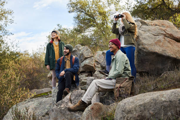 istock Smiling friends taking a break on some rocks while hiking 1182176909