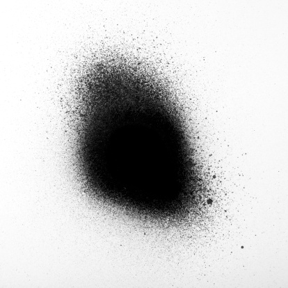 A DSLR photo of black spray paint on white background.The transition of paint dots is seen in high detail.The image was shot close up in studio in horizontal composition and cropped to square ratio.The intensive paint is on the centre of frame. 