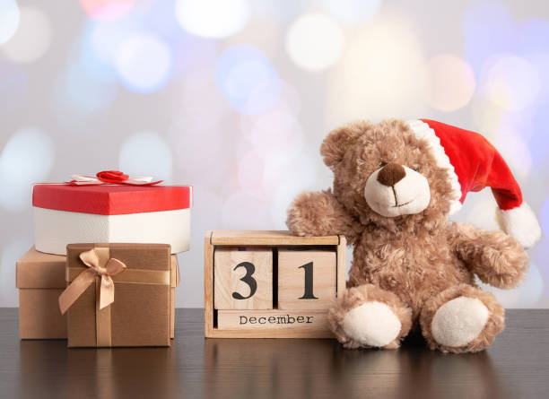 istock brown teddy bear and a stack of various cardboard boxes for gifts on a black table 1182179573