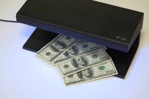istock Dollar bills lie inside black metal detector 1182180704