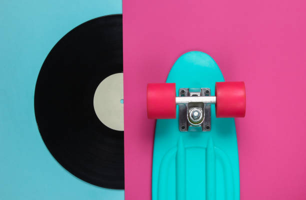 istock Retro style. Plastic mini cruiser board and vinyl record on colored background. Pastel color trend. Summer fun. Youth minimalistic concept. 80s. Top view 1182181894