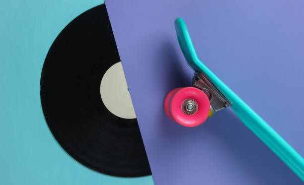 istock Retro style. Plastic mini cruiser board and vinyl record on colored background. Pastel color trend. Summer fun. Youth minimalistic concept. 80s. Top view 1182181929