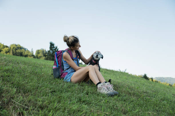 istock Young female hiker taking a break sitting in grass 1182183054