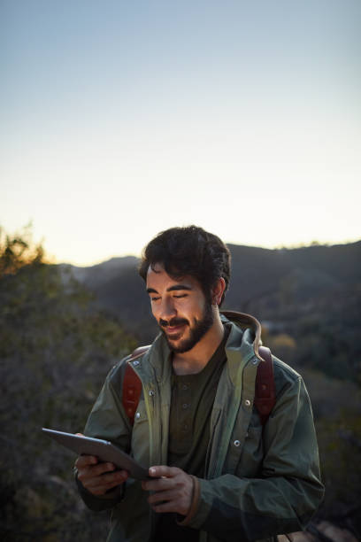istock Smiling young hiker using the gps on his digital tablet 1182184416