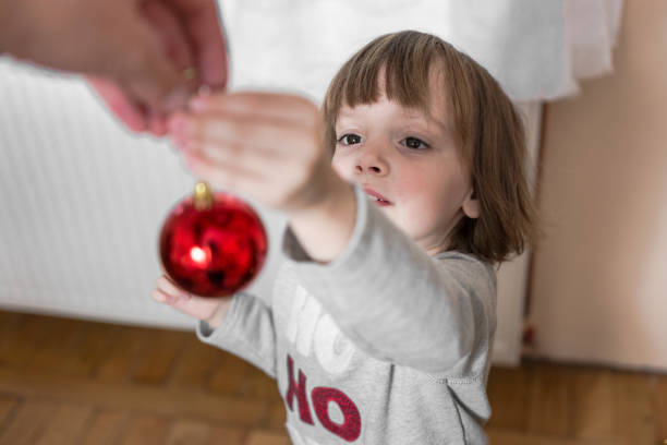 Child with a Christmas ornament.