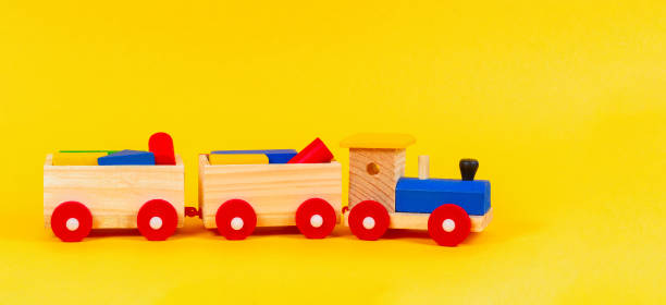 istock Wooden toy train with colorful blocks on yellow background 1182187145