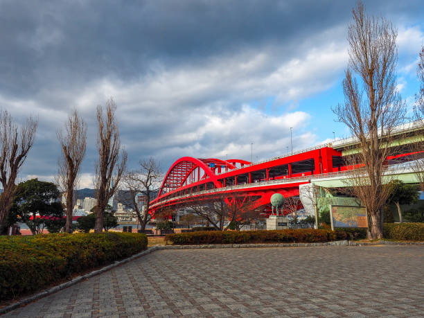 nuages foncés au-dessus du grand pont rouge - large transportation bridge famous place photos et images de collection