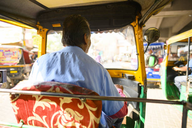 um motorista não identificado está montando um auto rickshaw através das ruas movimentadas de jaipur. - india mumbai delhi crowd - fotografias e filmes do acervo