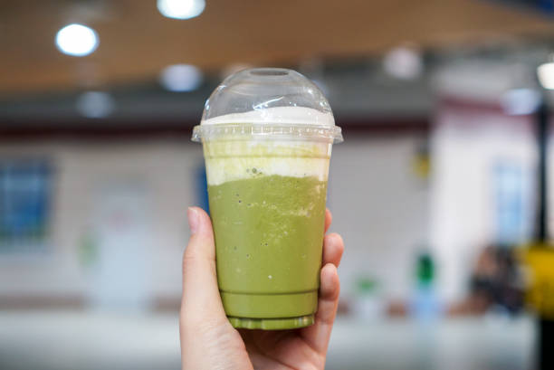 A plastic cup of blended matcha green tea topped with cream cheese mousse.
