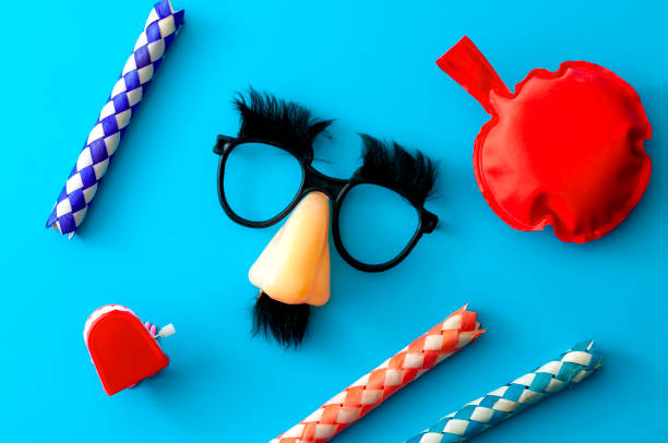 Comical prank, April fools practical joke and goofy disguise concept farting bag, chattering teeth, chinese finger trap and novelty glasses with fake nose and eyebrows isolated on blue background Comical prank, April fools practical joke and goofy disguise concept farting bag, chattering teeth, chinese finger trap and novelty glasses with fake nose and eyebrows isolated on blue background fool photos stock pictures, royalty-free photos & images