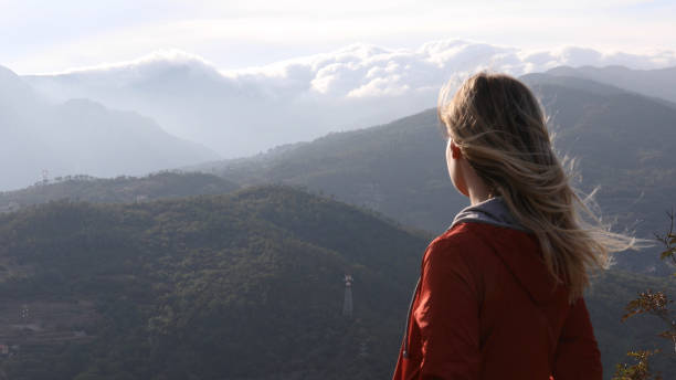istock Female hiker relaxes above hillside at sunrise 1182202761