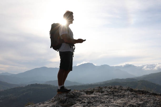 istock Male hiker relaxes above hillside at sunrise 1182202766