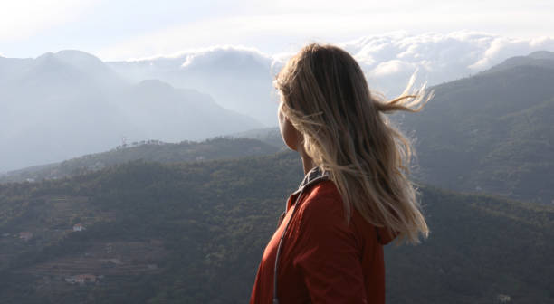 istock Female hiker relaxes above hillside at sunrise 1182202796