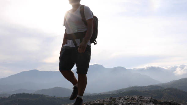 istock Male hiker relaxes above hillside at sunrise 1182202803