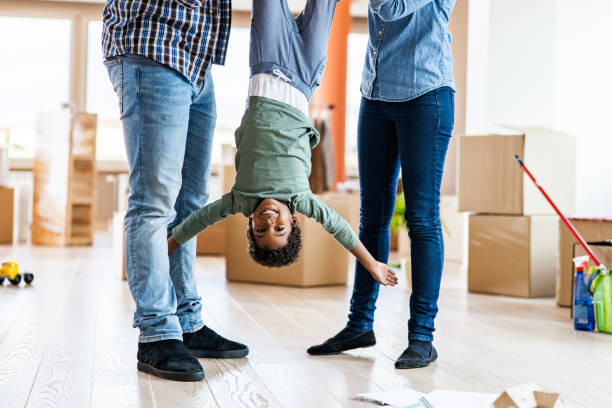 istock Happy black boy held by his parents upside down at new apartment. 1182202920