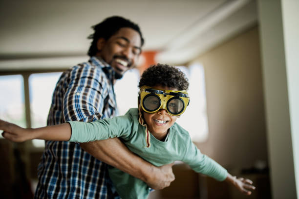Happy black boy having fun with his father at home.