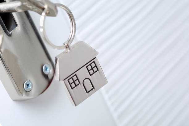 istock Home key with metal house keychain in keyhole 1182204754