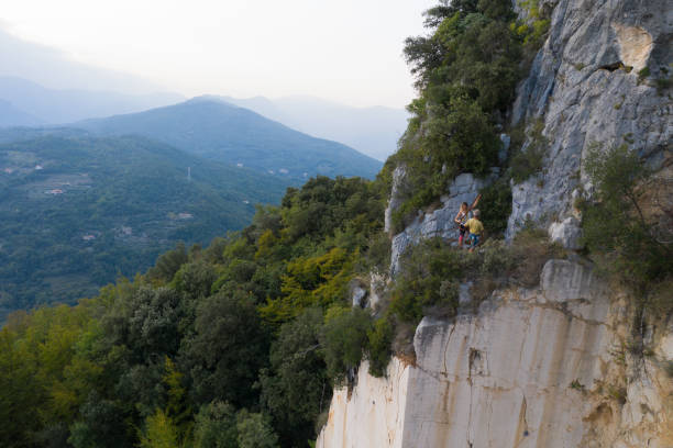 Female mountain climber uncoils the climbing rope