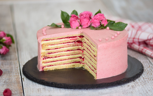 Layers cake with berry filling decorated with fresh roses