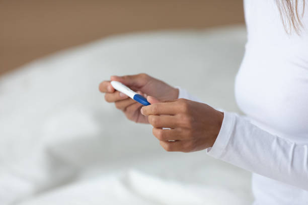 istock Young mixed race woman holding quick plastic pregnancy test in hands. 1182206024