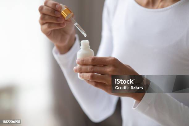 Close Up Young Woman Holding Bottle With Pipette Stock Photo - Download Image Now - Skin Care, Acid, Merchandise