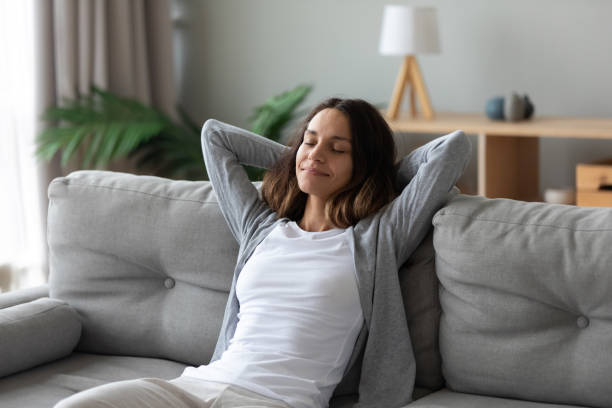 istock Tranquil smiling biracial millennial woman leaning on sofa. 1182206217