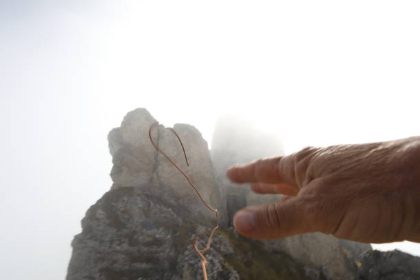 istock Mountaineer throws rope to rock pinnacle 1182206400