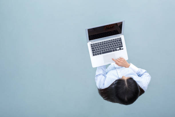 istock Young woman standing top view business concept browsing laptop 1182207564