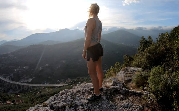 istock Female trail runner reaches ridge crest at sunrise 1182208679