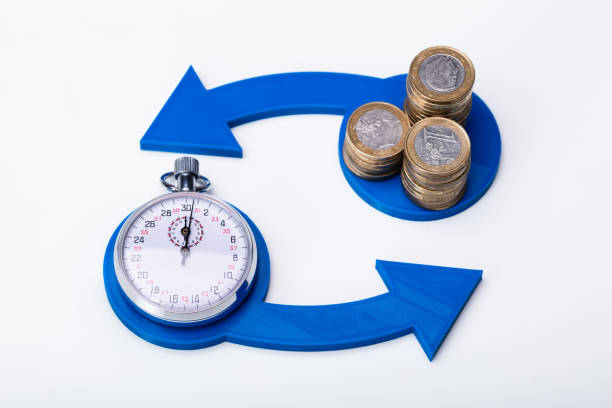 Stacked Coins And Stopwatch in Exchange Time For Money Concept