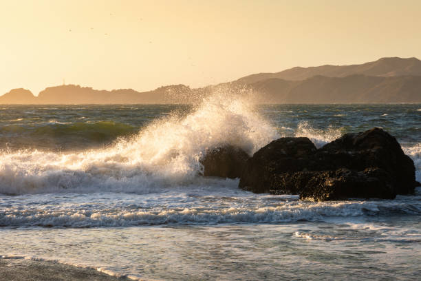 istock Big wave from hard wind touching big rock of Baker Beach at sunset 1182214719