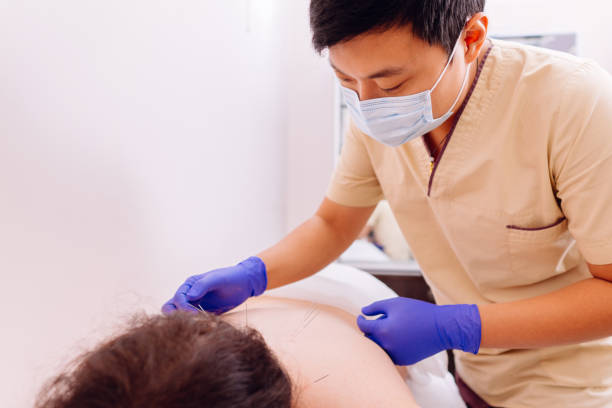 istock Physiotherapist doing acupuncture on woman's back 1182214822