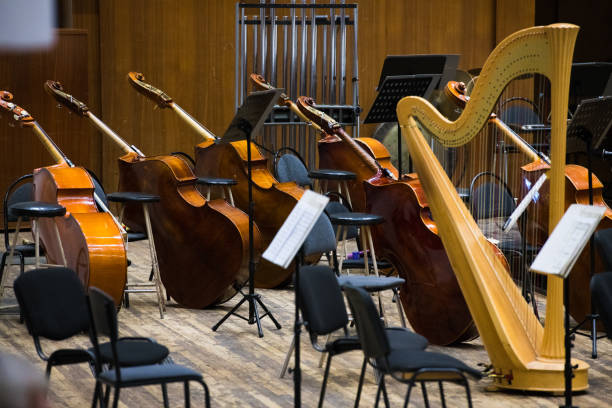The stage is ready for the orchestra. Musical instruments, score, microphones.