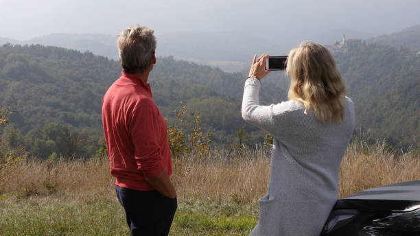 istock Couple relax against car while finding directions for their trip 1182214856