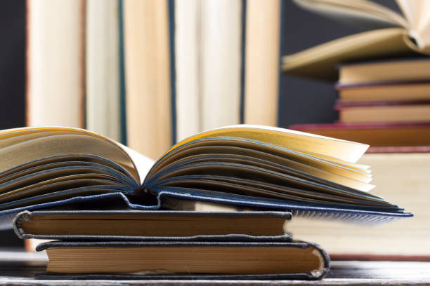 istock Open book, hardback books on wooden table. Back to school. Copy space 1182217286