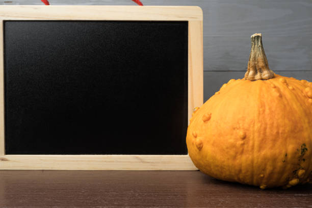 istock Orange halloween pumpkin with blank chalk blackboard. 1182218922