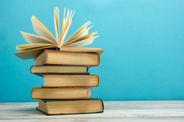 istock Open book, hardback books on wooden table. Back to school. Copy space 1182219466