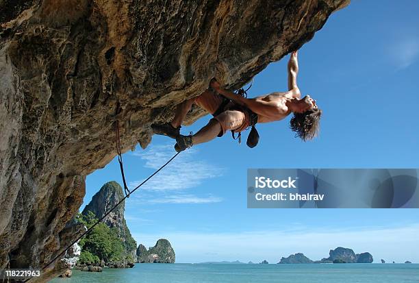 Man Climbing A Rock With The Ocean Around Him Stock Photo - Download Image Now - Achievement, Active Lifestyle, Activity