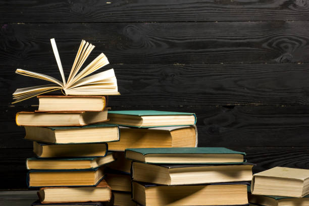 istock Open book, hardback books on wooden table. Back to school. Copy space 1182219991