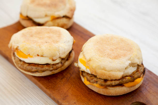 istock Homemade pork roll egg sandwich on a rustic wooden board on a white wooden table, low angle view. Close-up. 1182220145