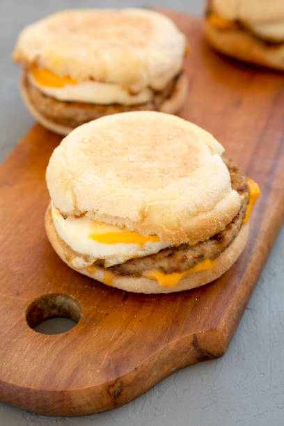 istock Homemade pork roll egg sandwich on a rustic wooden board on a concrete background, side view. Close-up. 1182221019