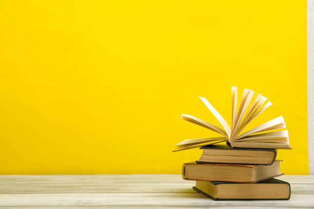 istock Open book, hardback books on wooden table. Back to school. Copy space 1182221374