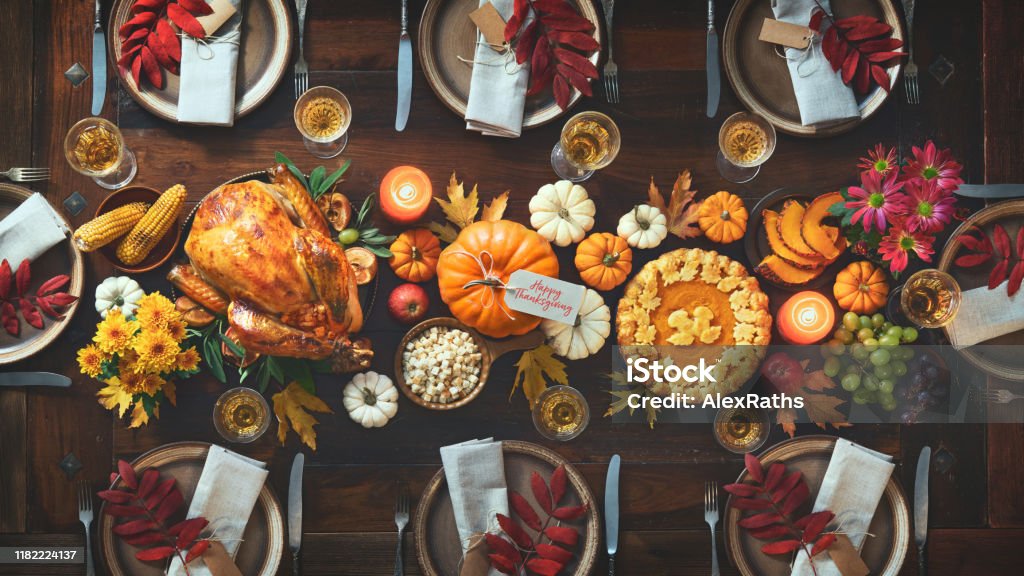 Thanksgiving celebration traditional dinner Thanksgiving celebration traditional dinner. Roasted turkey garnished with cranberries on a rustic style table decoraded with pumpkins, vegetables, pie, flowers and candles. Festive table setting Thanksgiving - Holiday Stock Photo