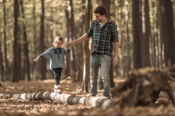 istock Dad and daughter walking in the autumn forest. 1182225316