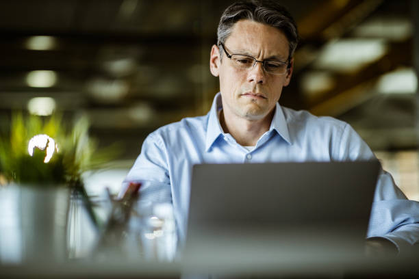 istock Mid adult businessman working on a computer in the office. 1182226156