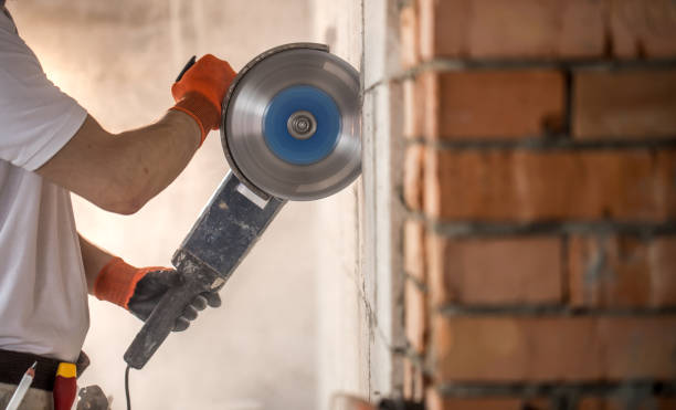 istock The industrial Builder works with a professional angle grinder to cut bricks and build interior walls. Electrician. 1182226283