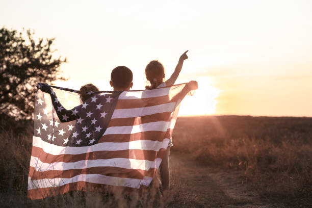 uma família feliz com uma bandeira americana no por do sol. - circa 4th century fotos - fotografias e filmes do acervo