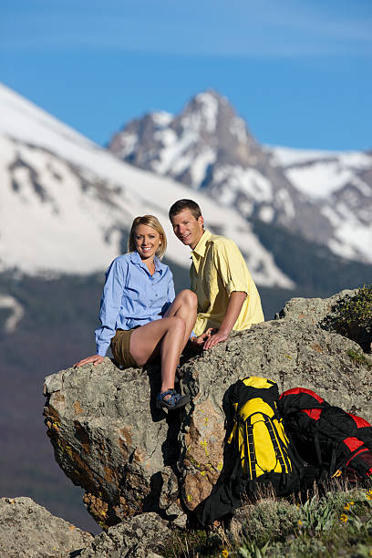 istock Two Backpackers Sitting On Huge Mountain Rock After Climb 118222694