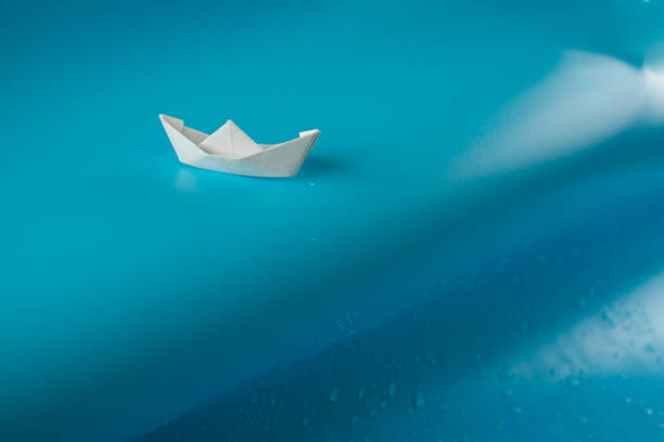 istock Paper ship sailing on big wave 1182227269